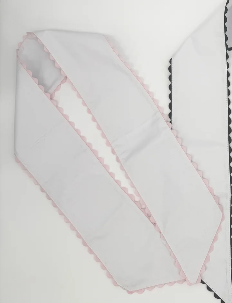 Two white wreath sashes with ric rac trim, one in pink and one in red
