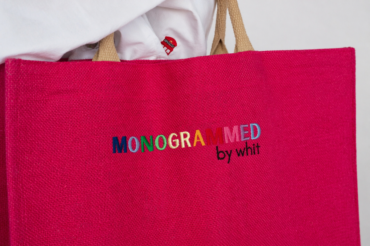 A hot pink canvas tote embroidered with the rainbow Monogrammed by Whit logo