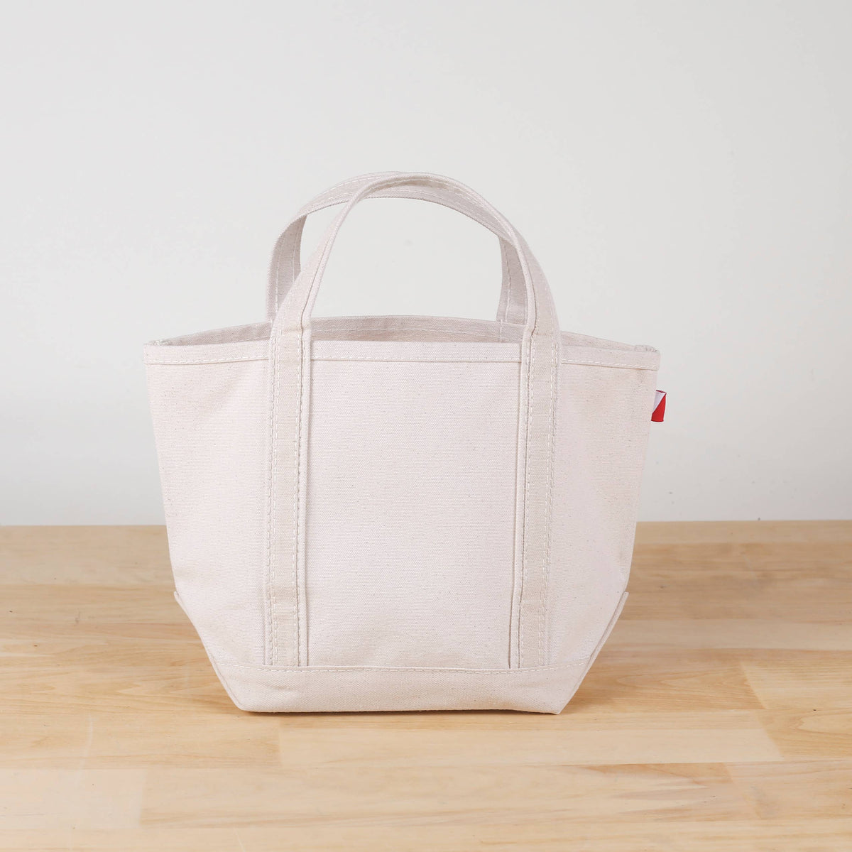 Mini natural canvas tote with natural-colored handles and trim