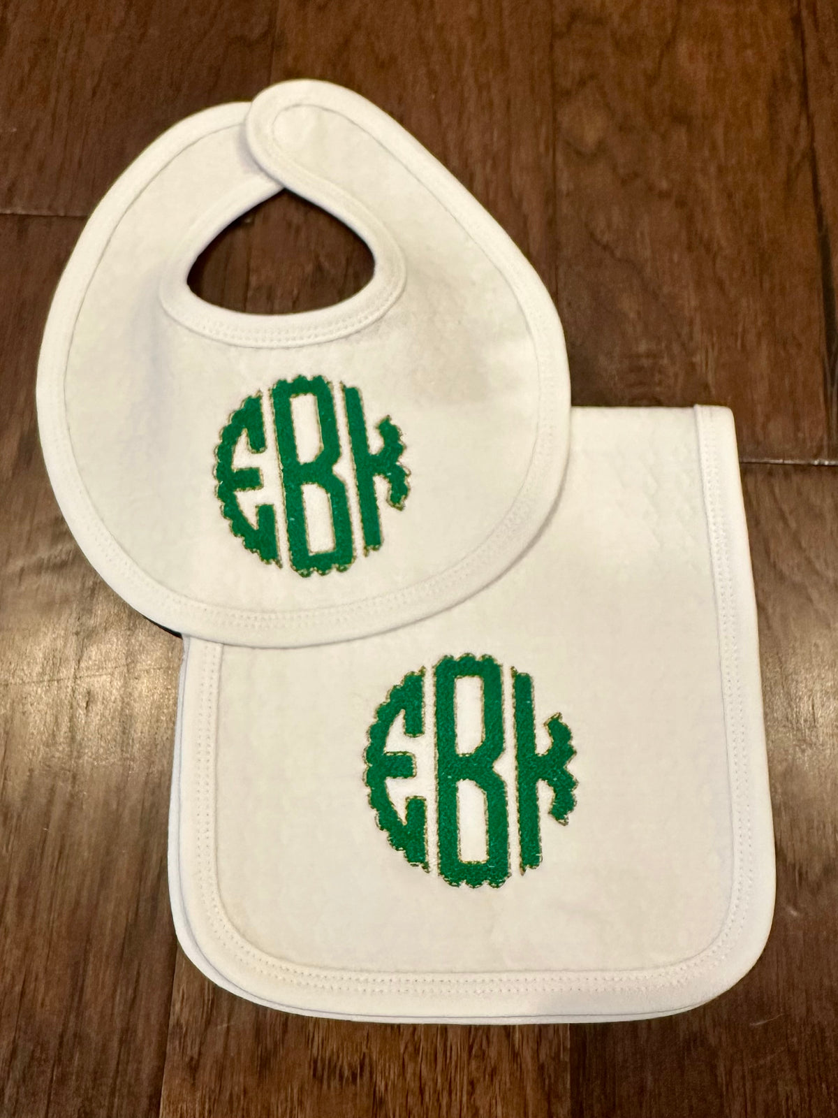 White baby bib and burp cloth monogrammed with a green circle EBK monogram