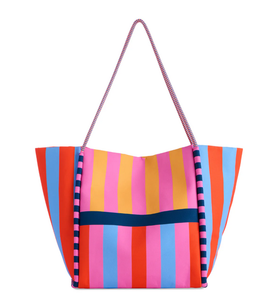 Large striped tote in blue, orange, pink and red with navy pom trim and rope handles.