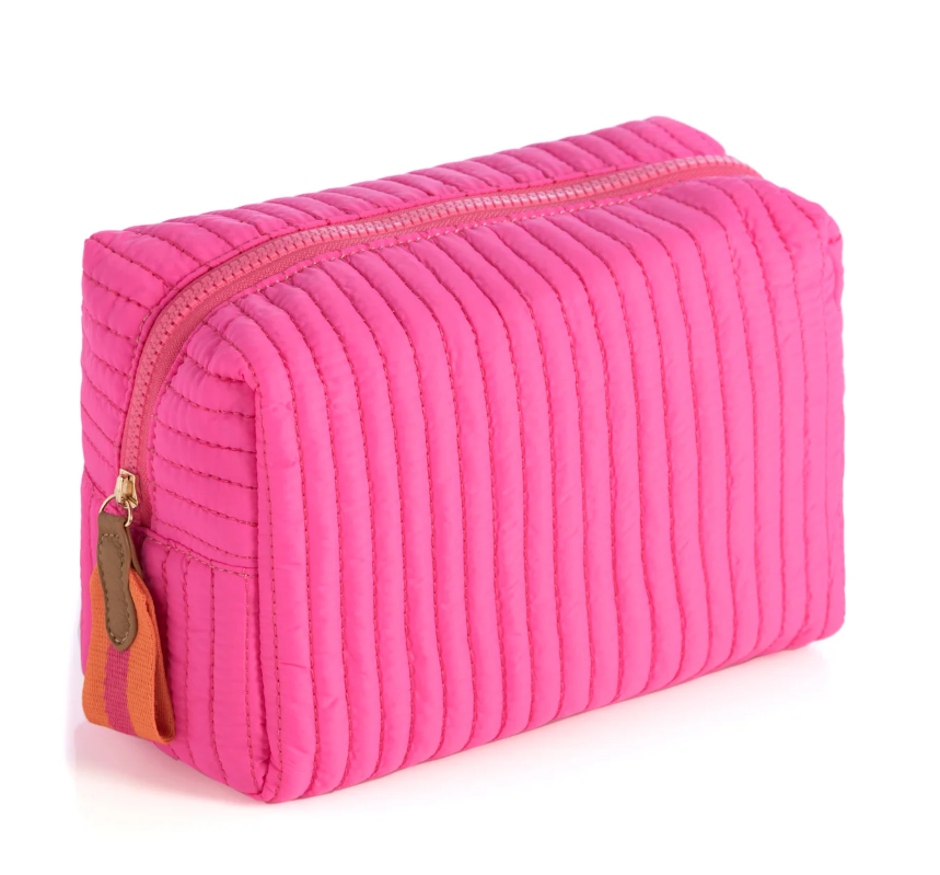Hot pink quilted zipper pouch with vertical channels and an orange-tan zip pull