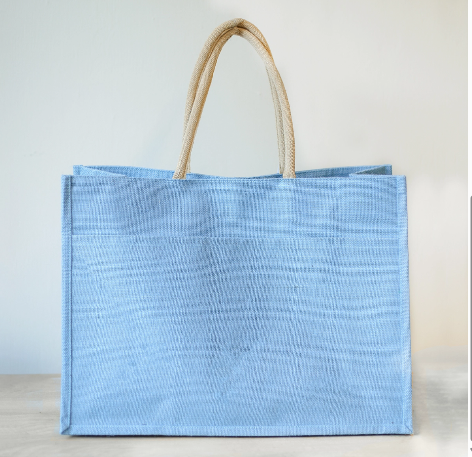 Inside of the jute tote showing the lining, an interior pocket, and leather handle attachments