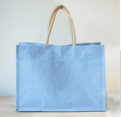 Inside of the jute tote showing the lining, an interior pocket, and leather handle attachments