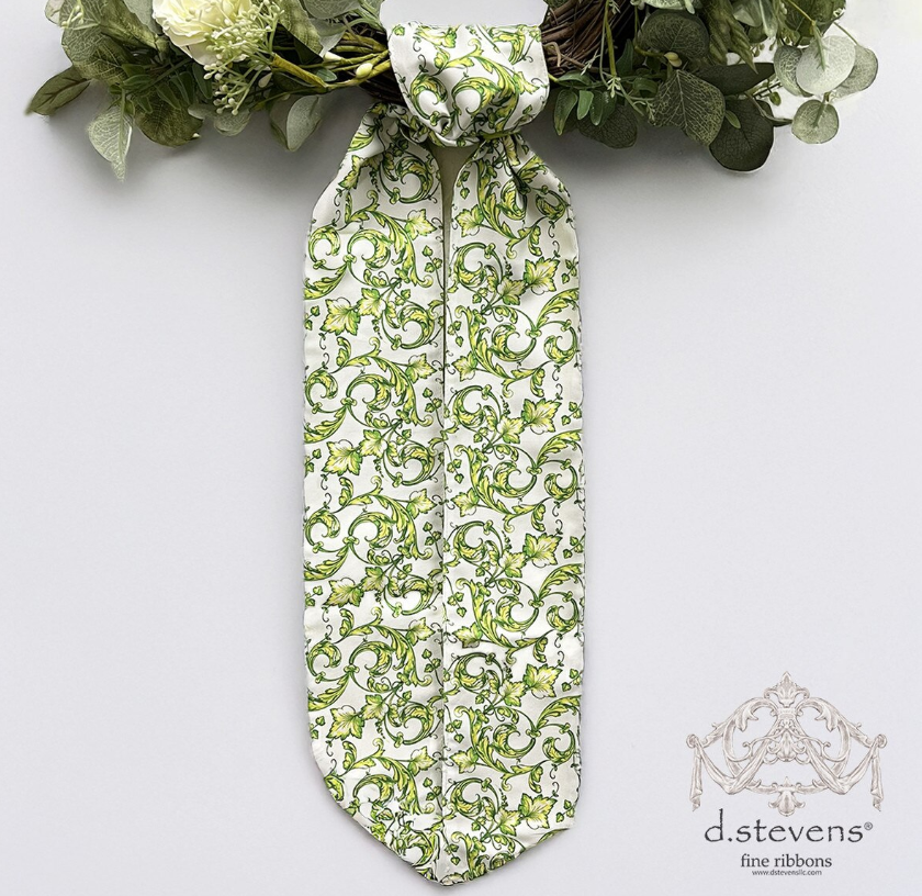 Green and white patterned wreath sash tied on a wreath with white flowers