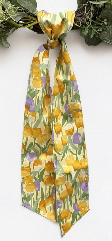 Patterned wreath sash with golden orange and purple tulips on a pale green background