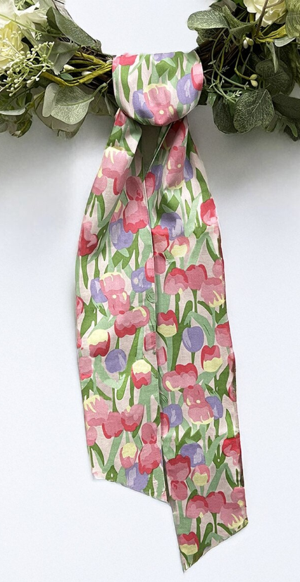Patterned wreath sash with pink and purple tulips on a soft green background