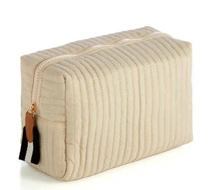 Beige quilted zipper pouch with vertical channels and a brown and black-and-white striped zip pull