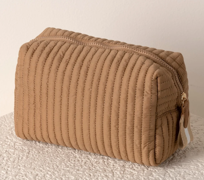Brown quilted zipper pouch with vertical channels and a cream zip pull
