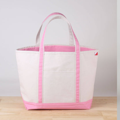 Large natural canvas tote with light pink handles, pink trim, and a pink bottom
