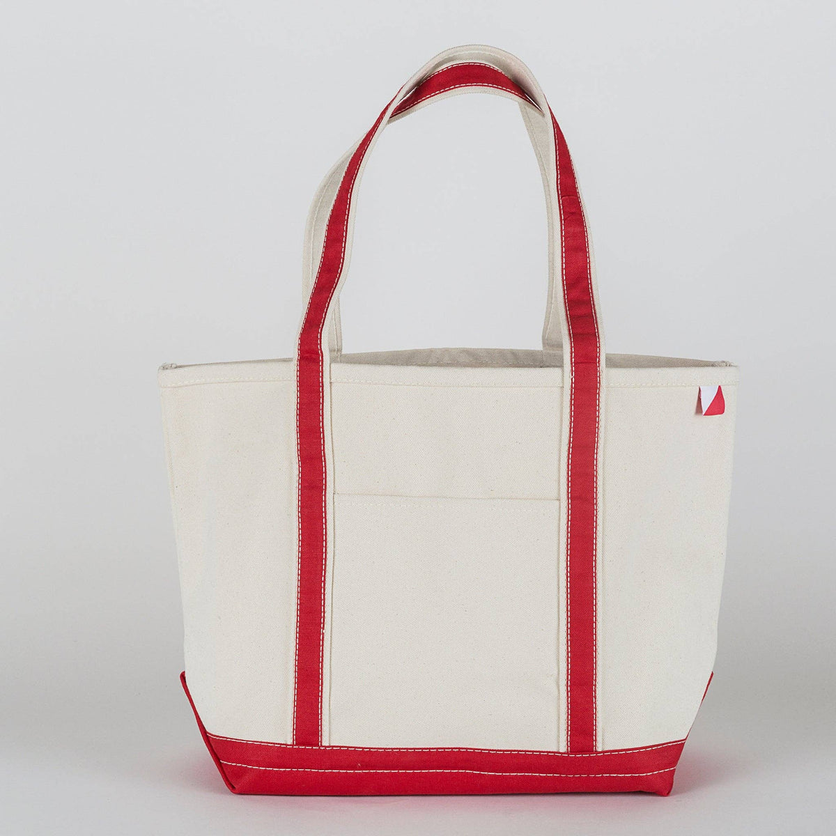 Natural canvas tote with red straps, trim, and base, shown from the front